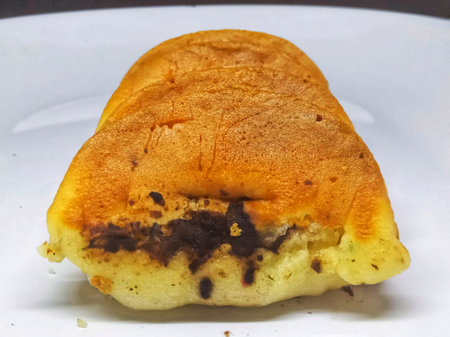 bun with chocolate chips on a white plate. close-upの写真素材