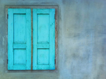 Old blue wooden window on cement wall, vintage and retro style.の写真素材