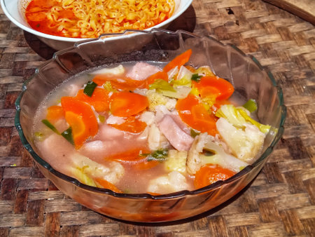 Soup with vegetables and meat in a glass bowl on the tableの写真素材