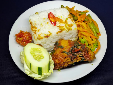 Fried fish with vegetables and rice on a white plate.の写真素材
