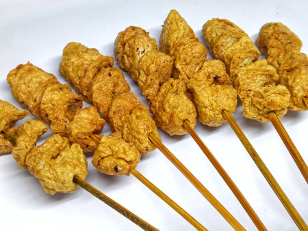 Fried pork rinds on a stick on a white backgroundの写真素材
