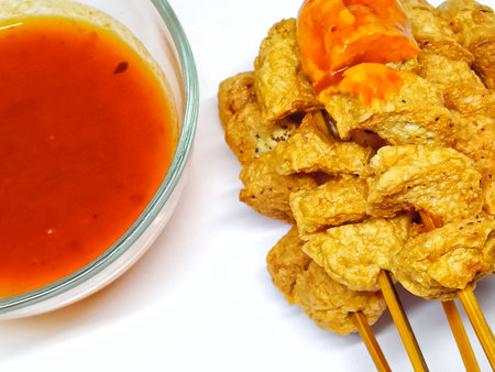 Fried pork rind with sweet and sour sauce on white backgroundの写真素材