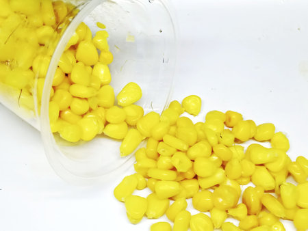 Corn seeds in a plastic cup on a white background close-upの写真素材