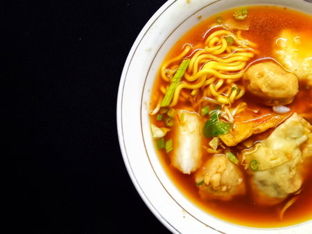 Noodle with fish ball in white bowl on black backgroundの写真素材