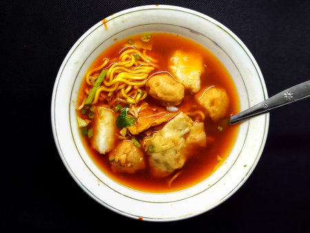 Thai style noodle soup with pork ball in white bowl on black backgroundの写真素材