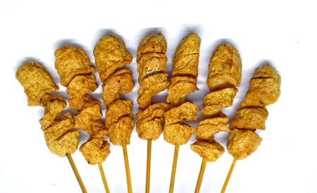 Deep-fried pork on a stick isolated on a white background.の写真素材