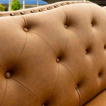 Close up of pins and buttons on a vintage style sofa. Buttoned vintage sofa up close.