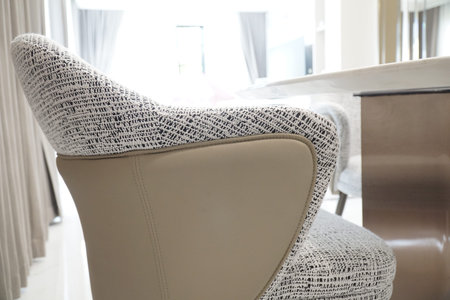 Chair with a white and black pattern is sitting in front of a table. The chair is made of leather...
