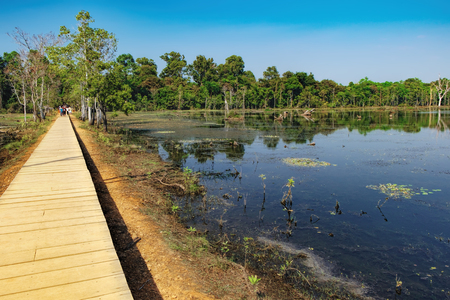 Mysterious wooden path towards Neak Pean Temple through artificial island in Angkor Complex, Siem Reap, Cambodia. Ancient Khmer architecture, famous Cambodian landmark,の写真素材