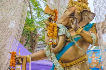 The old Ganesha statue is set for people to worship in Wat Arun, Bangkok, Thailand. Chains of Thai Paper Money Hung offering in Buddhist Temple for Good Luckの写真素材