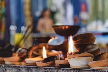 Burning old textured candles with defocussed background of the most popular Hindu shrines outside India - Batu Caves. Mood of sacrament and revelation.の写真素材
