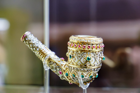 Kuala Lumpur, Malaysia - February 11, 2016: Ancient golden smoking pipe in precious stones at the Islamic Arts Museum in Kuala Lumpur, Malaysia. Selective focusのeditorial素材