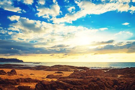 Coast of the sea at colorful sunset, Nang Thong Beach, Khao Lak, Thailand. Beach sunset is a golden sunset sky with a wave rolling to shore as the sun sets over the ocean horizonの写真素材