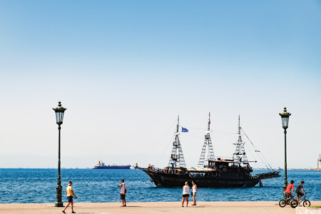 Thessaloniki, Greece - September 14, 2017: Amazing view of seafront with walking people and Thermal Bay in Thessaloniki, Central Macedonia, Greece. Tourist ship in Thessaloniki portのeditorial素材