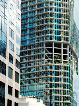 Singapore - January 17, 2018: Ultra modern Capitagreen office tower with live tropical plants on each floor located near Raffles Place, Singapore. View of the downtown core of Singaporeのeditorial素材