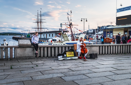 Oslo, Norway - August 3, 2018: Young stylish musician playing the Cello on the Radhusplassen, City Hall pier in Oslo, Norwayのeditorial素材