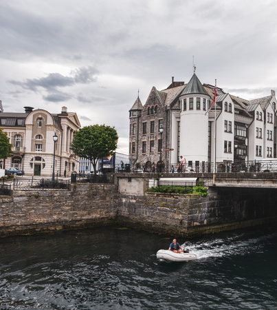 Alesund, Norway - July 31, 2018: Cruise Powerboat with tourist at the Alesund town, old architecture of Alesund city centre on the backgroundのeditorial素材
