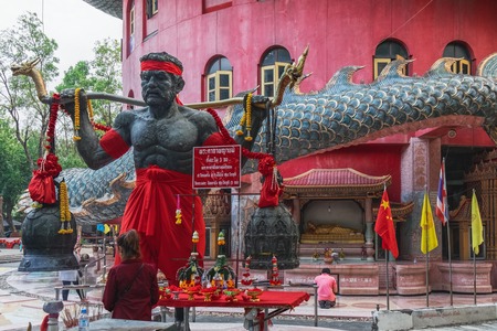Nakon Pathom, Thailand - February 5, 2018: Religious offerings in the courtyard of red temple with Giant Chinese dragon Wat Samphran, Nakhon Pathom province, near Bangkok, Thailandのeditorial素材