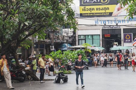 Bangkok, Thailand - February 28, 2018: Thai young musician playing the violin at the entrance to the Tha Prachan Pier in Bangkok, Thailandのeditorial素材