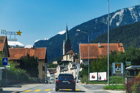 Switzerland, Domat - August 24, 2019: View from Via Hauptstrasse on Nova Church of St. John the Baptist in Domat, Domat Ems municipality in the Imboden Region, canton of Graubunden, Switzerland.のeditorial素材