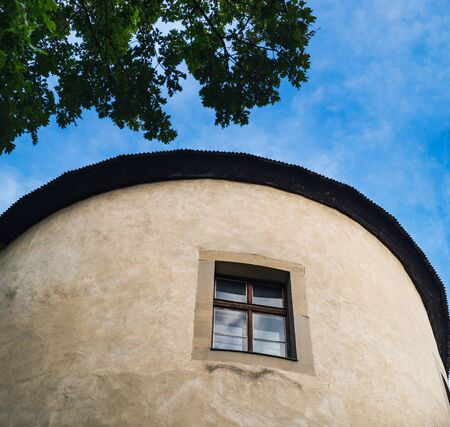 Medieval Tower with window of Zvolen Castle in Zvolen town, Slovakia. Panoramic summer view framed by tree leavesの写真素材