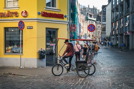 Riga, Latvia - July 21, 2018: Tricycle rider is waiting for passengers in Old Town of Riga, Latviaのeditorial素材