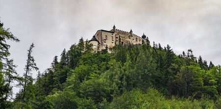 Hohenwerfen Castle is a medieval rock Alpine castle and history museum near Salzburg, Austrian Alps, Austria. It is surrounded by pine forests. Castle view on a rainy summer evening at sunsetのeditorial素材