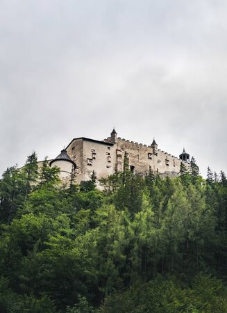 Hohenwerfen Castle is a medieval rock Alpine castle and history museum near Salzburg, Austrian Alps, Austria. It is surrounded by pine forests. Castle view on a rainy summer evening at sunsetのeditorial素材