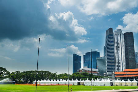 Modern skyline of Singapore city, urban asian cityscape with skyscraper buildings and green grass field in commercial business districtのeditorial素材