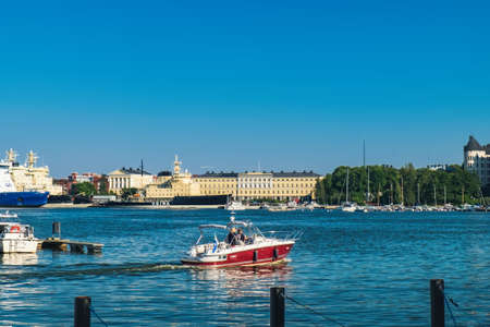 Helsinki, Finland - July 25, 2018: Tourist boat with tourists in sea harbor, scenic Scandinavian Old Town pier in Katajanokka district, famous tourist destination of Helsinki cityのeditorial素材