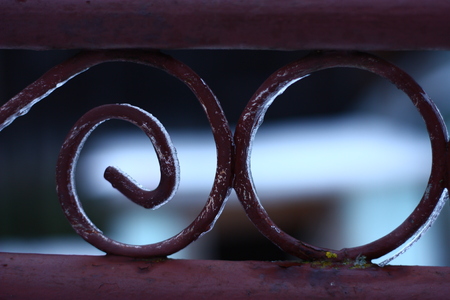 Detail on rusty old iron fence frozen in winterの写真素材