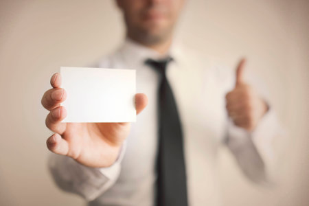 Blank Card holded by hand and thumbs upの写真素材