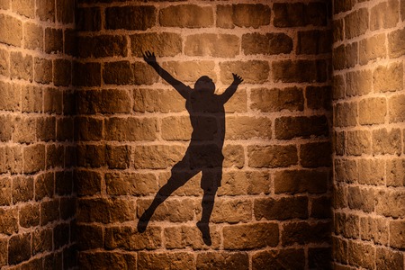 Jumping man Shadow on the wallの写真素材