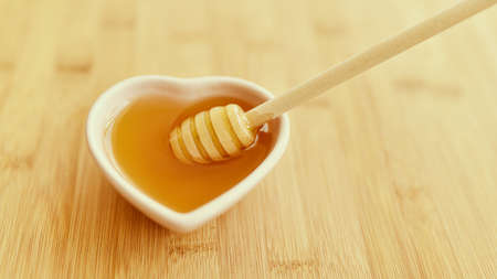 Bowl of honey on wooden table.の写真素材