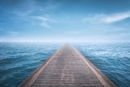 Wooden pier with blue sea and sky backgroundの写真素材