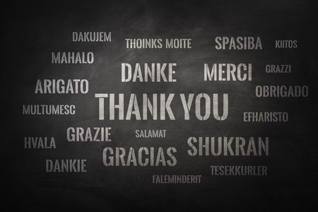 Thank you word cloud written in many different languages on a chalkboardの写真素材