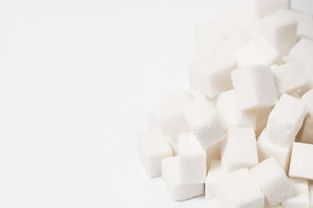 Sugar background sweet food ingredient with a close up of a pile of delicious white lumps of cubes as a symbol of cooking and baking and the diet health risks related to diabetes and calorie intake.の写真素材