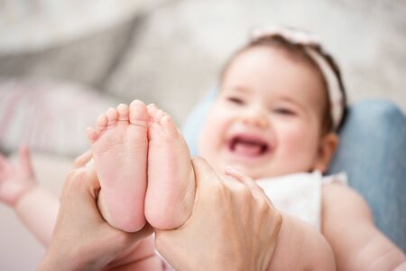 Mother massaging her baby girlの写真素材