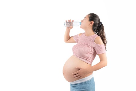 The young pregnant woman with a glass of waterの写真素材