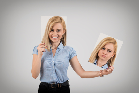 Young woman changing mood from being happy to getting upset and angryの写真素材