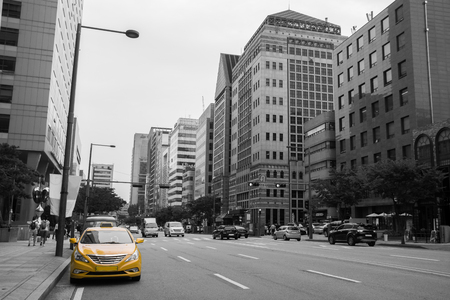 South Korea. Taxi in yellow color in the traffic light with building and car in backgroundの写真素材