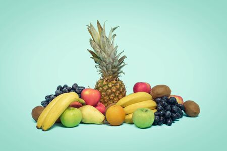 close up of various seasonal fruits with oranges,pineapple,bananas, apples and kiwis