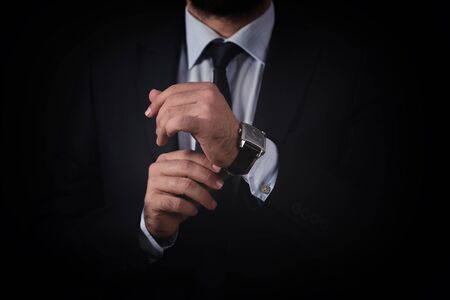 Businessman checking time from watch