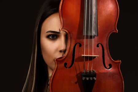 Violinist Woman portrait with violin on backgroundの写真素材