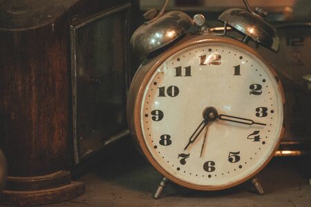Vintage background with antique retro alarm clock on tableの写真素材