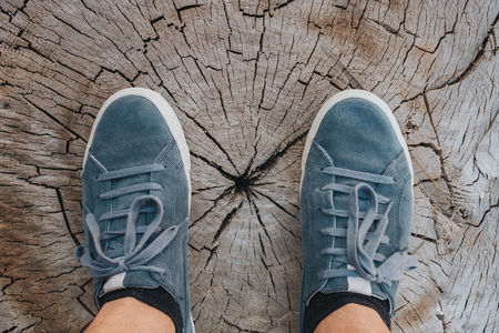 Blue leather sneakers on wood background, top view, fashion lifestyle concept