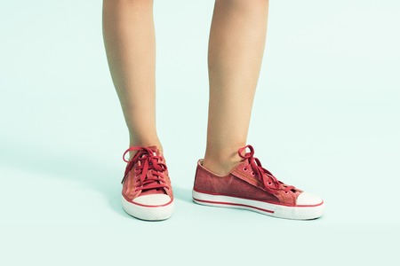 Women shoes. sports shoes ,sneakers. Closeup of woman legs and feet wearing red shoesの写真素材
