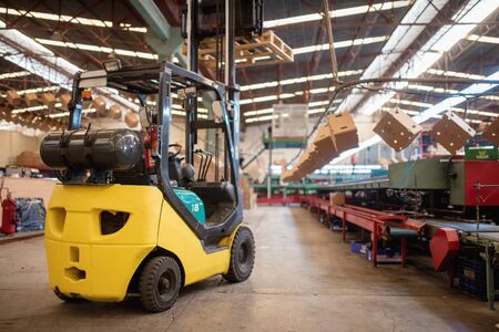 The forklift is in a large and light warehouse. Yellow color.の写真素材