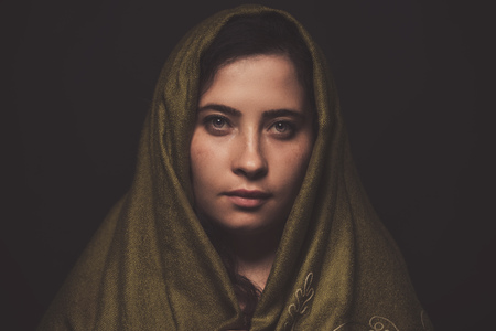 beautiful woman portrait with green scarf over her head, studio shot.の写真素材
