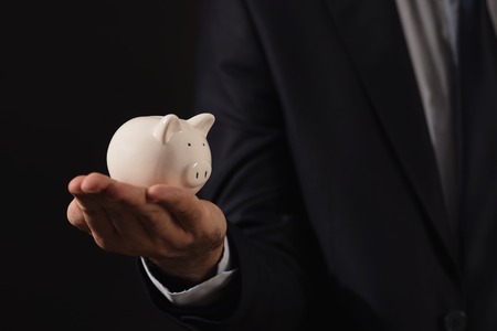 Young businessman holding white piggy bank.Finance conceptの写真素材